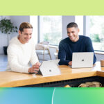 A couple of men looking at laptops